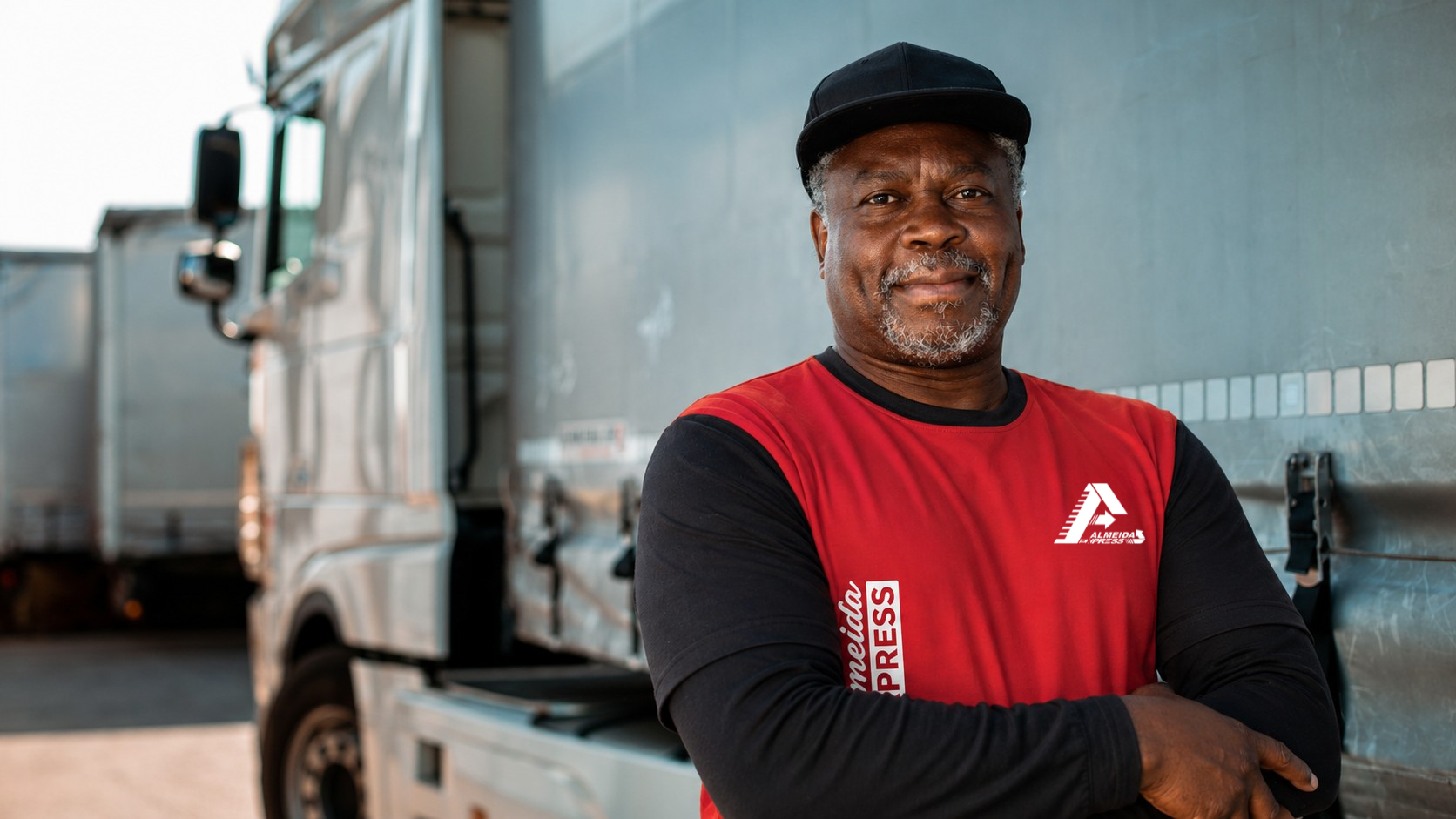 Colaborador Almeida Express com uniforme em frente ao caminhão